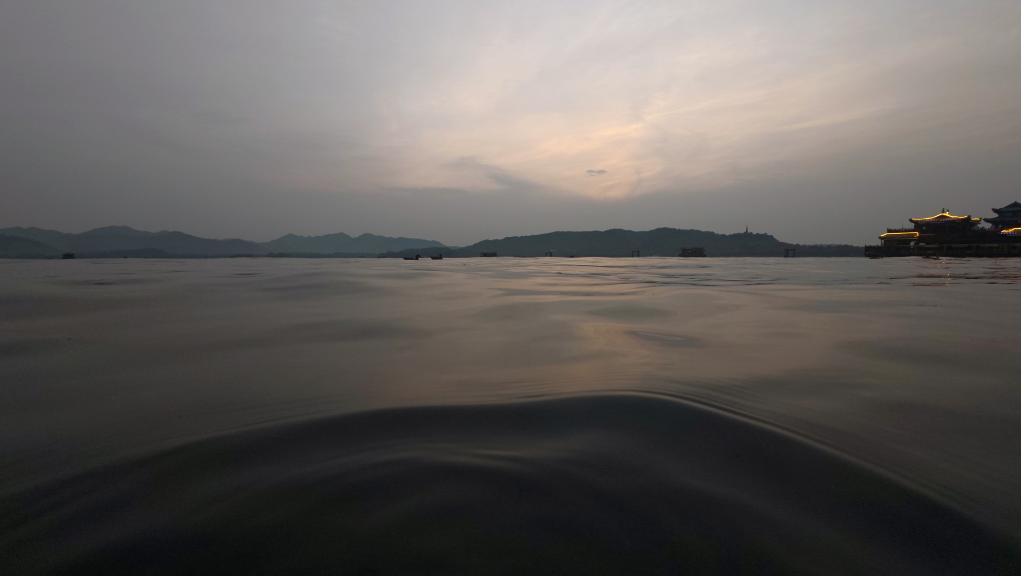 杭州 · 西湖的傍晚，远处的山影与湖畔灯火